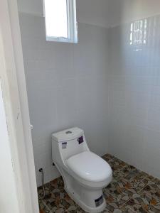 贡布Home Daun Kam的浴室设有白色卫生间和窗户