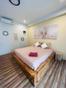 通萨拉绿芒果公寓的一间卧室配有一张铺有木地板的床。