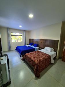 San Juan del ParanáHotel Villa的一间带两张床的卧室和一台电视