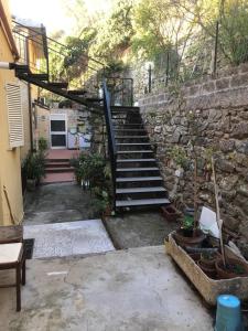 卡斯蒂里昂纳·德拉佩Appartamento incantevole a 100mt dal mare的楼梯通往带石墙的房子