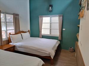 台南古都101民宿 適合2至7人包棟的配有两张床铺的蓝色墙壁和窗户