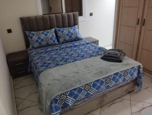 拉腊什AlMohit Larache的一张带蓝色和白色棉被和枕头的床