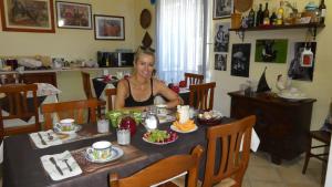 奥列纳奥列纳住宿加早餐旅馆的坐在餐桌上吃一盘食物的女人