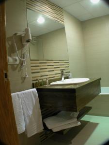 巴尔洪克拉马塔兰亚之门酒店的浴室配有盥洗盆、镜子和毛巾