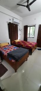 菩提伽耶Kalawati Niwas的一间卧室配有两张床和吊扇