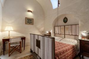 卡斯特里尼亚诺德尔卡波Antica corte dell'800的一间卧室配有一张床和一张带台灯的桌子
