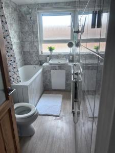 哈洛Parsonage Leys的浴室配有卫生间、浴缸和水槽。