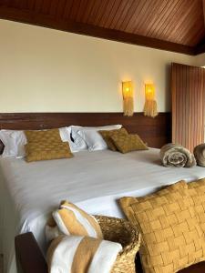 雅帕拉廷加Kuarasy Boutique Hotel Japaratinga的卧室配有带枕头的大型白色床
