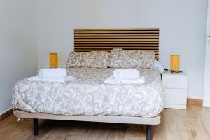 塞维利亚Triana Riverside Guesthouse的一间卧室配有一张床,上面有两条毛巾