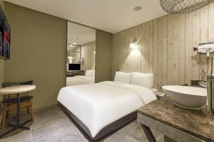首尔HERTZ Hotel的卧室配有白色大床和水槽