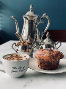 伦敦Luxury mid century Apartment的一杯咖啡和盘子里的糕点,茶壶