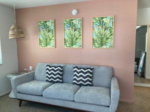 维洛海滩Seaspray Surf Lodge的客厅配有沙发,墙上有三幅画作