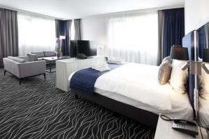 蒙斯Van der Valk Hotel Mons Congres的酒店客房设有床和客厅。