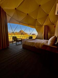 瓦迪拉姆Mirage Camp Wadi Rum的帐篷内的一张床位,享有沙漠美景