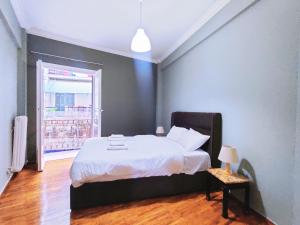 雅典WSD Cozy Stylish 1BD Suite for Couple or Business的一间卧室配有一张带白色床单的床和一扇窗户。