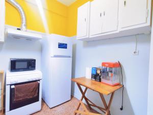 雅典WSD Cozy Stylish 1BD Suite for Couple or Business的小厨房配有白色冰箱和桌子