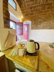 埃武拉Casa da Moeda的厨房柜台上的茶壶和两个杯子