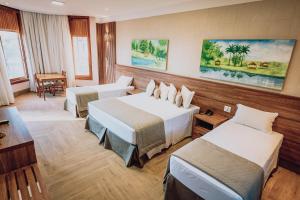 阿拉拉夸拉Hotel Fazenda Salto Grande的酒店客房设有两张床和一张桌子。