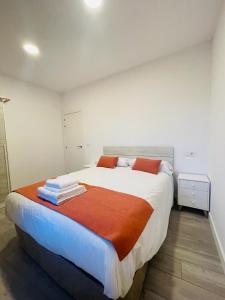 杜鲁埃洛德拉谢拉Apartamentos Rurales La Plaza 3的一间卧室配有一张带橙色和白色床单的大床