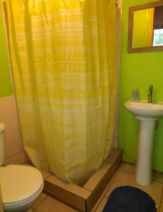 埃尔基斯科Cabañas Isla Neruda的浴室设有黄色的淋浴帘和水槽