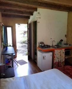 埃尔基斯科Cabañas Isla Neruda的客房设有厨房、床和桌子。