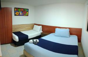 波哥大AG精品酒店的酒店客房,配有两张床和椅子