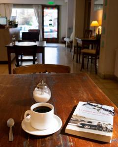 马德普拉塔Casa Nanet Hotel的一杯咖啡和一本书在桌子上