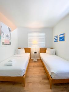 维洛海滩Seaspray Surf Lodge的一间设有两张床和一盏灯的房间