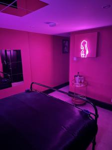 巴恩斯利The Indulging Basement的粉红色客房内的一间卧室,配有一张床