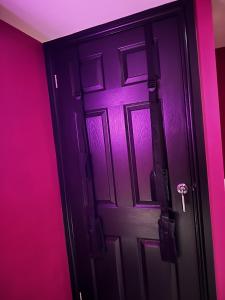 巴恩斯利The Indulging Basement的粉红色房间的一个黑色门