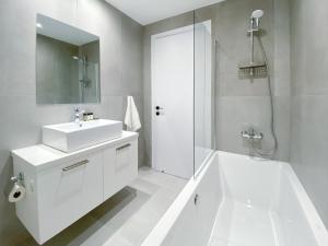 AglantziaPhaedrus Living White Hills Suites Panoramic View的白色的浴室设有水槽和淋浴。