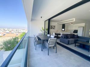 AglantziaPhaedrus Living White Hills Suites Panoramic View的用餐室以及带桌椅的起居室。