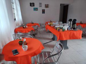 普拉亚弗朗西丝Torre do Sol的一间空餐厅,配有橙色的桌椅