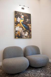 罗德镇Jensen Luxury Suites的墙上画画的房间里,有两把椅子