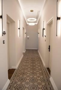 罗德镇Jensen Luxury Suites的一条空的走廊,铺着瓷砖地板,墙壁白色
