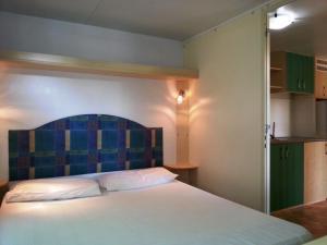 索托马里纳Villaggio Camping Europa的一间卧室配有一张大床和蓝色床头板
