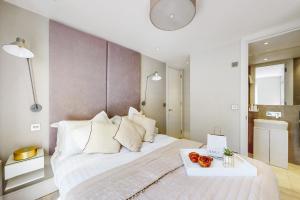 伦敦Park Lane Apartments Marylebone的卧室配有一张白色大床,上面有水果盘