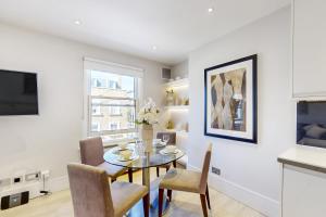 伦敦Park Lane Apartments Marylebone的厨房以及带桌椅的用餐室。