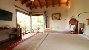 圣克里斯托瓦尔-德拉斯卡萨斯Hotel Casa de Familia de San Cristobal的一间卧室设有两张床、一张桌子和一个窗口。