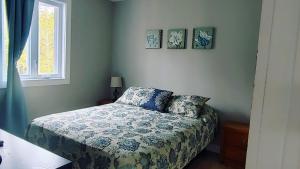 Saint-RaymondChalet Mathis的卧室配有一张床,墙上挂有两张照片