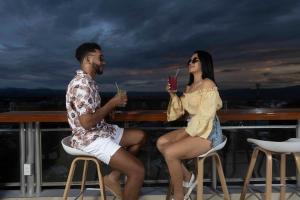 塔拉波托Rio Cumbaza Hotel的坐在阳台上喝饮料的男人和女人