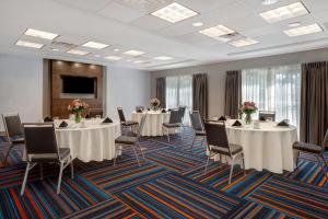 扬克斯杨克斯希尔顿恒庭旅馆&套房酒店的一间会议室,配有桌椅和屏幕
