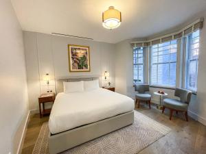 纽约Hotel Belleclaire Central Park的卧室配有一张白色大床和两把椅子