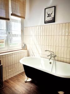 里摩日Maison d'hôte Les Allois的带浴缸的浴室和窗户