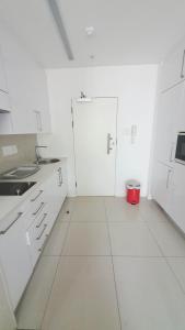 哈博罗内iTowers Studio-Suite的白色的厨房,配有白色的橱柜和红色的桶