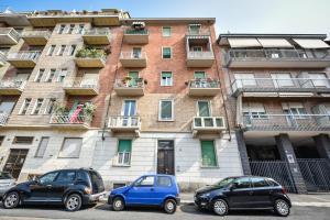 都灵Benvenuti Casa Leo - Elegante Appartamento的两辆汽车停在大楼前