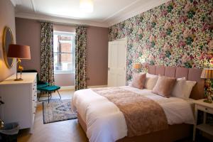 香农河畔卡里克No 1 St George’s Terrace.的一间卧室配有一张带花卉壁纸的大床