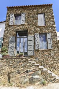 CortelazorCasa de Piedras by SIERRA VIVA desing的一面设有窗户的石头建筑