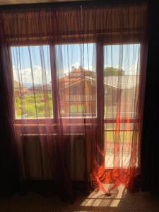 班斯科Iglika Bansko的窗户配有窗帘,享有房屋的景致