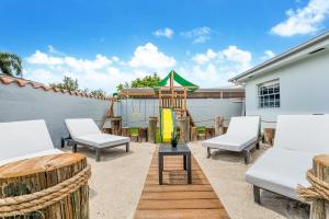 迈阿密Modern Chic Retreat Pool Full amenities backyard L10的一个带白色椅子的庭院和游乐场